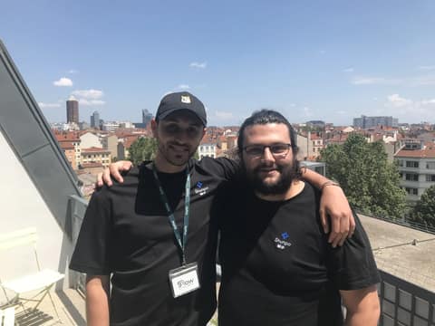 Deux membres de l'équipe SHUNPO posant sur un toit-terrasse, avec les toits de Lyon derrière eux.