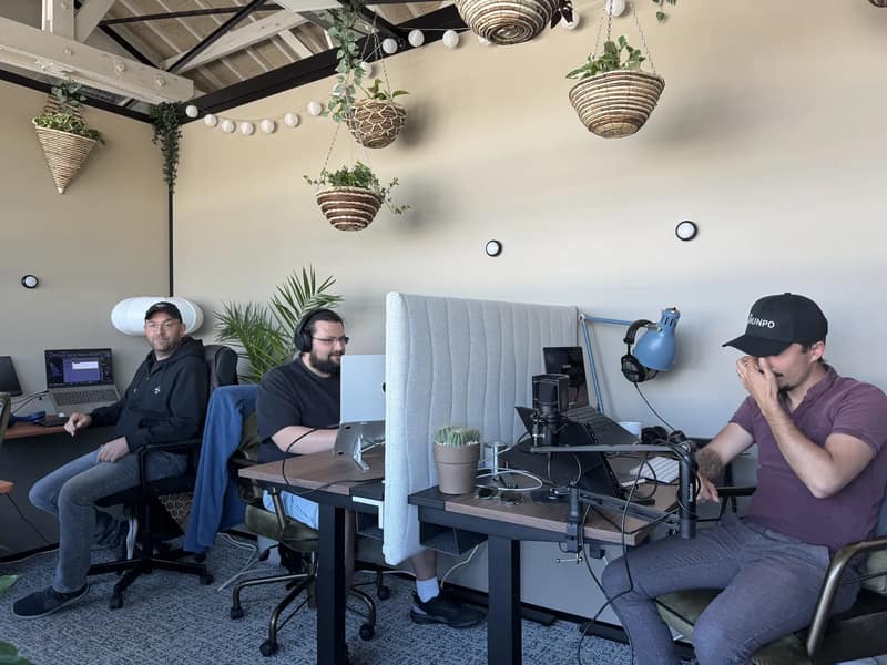 Deux membres de l'équipe SHUNPO à leur poste dans les bureaux, un casque sur les oreilles.