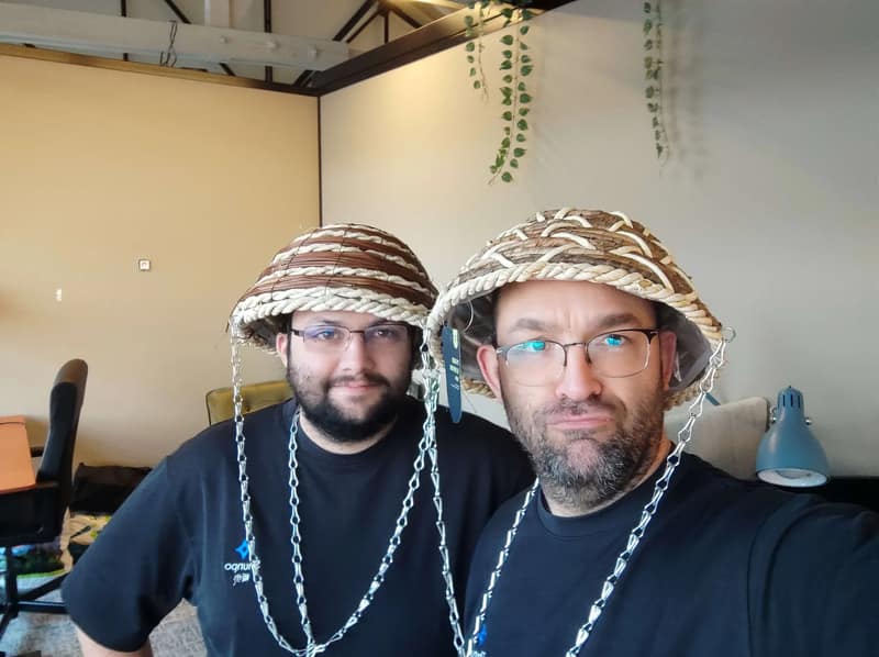Selfie de deux membres de l'équipe SHUNPO coiffés de chapeaux de paille tressés, dans les bureaux.