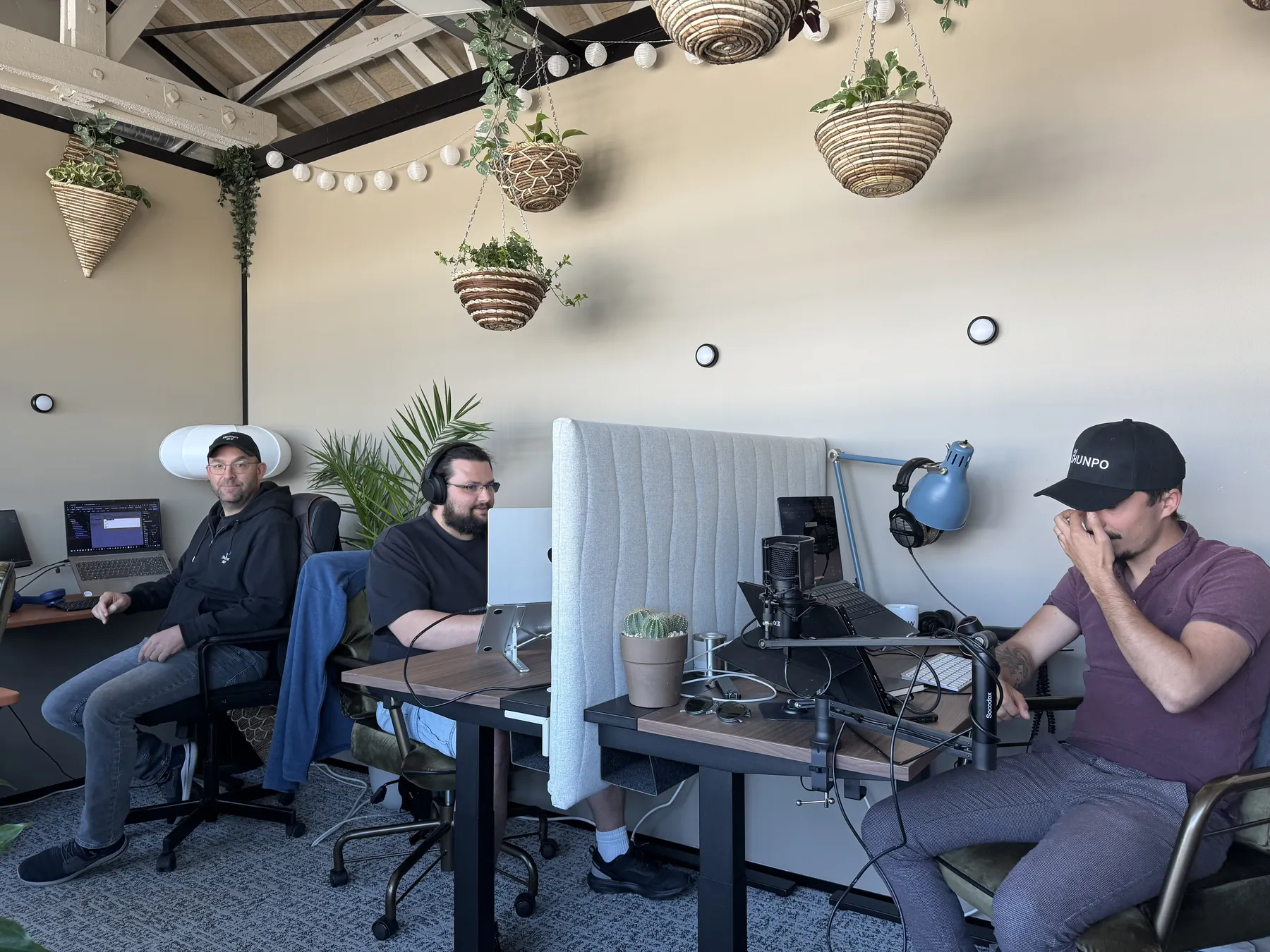 Deux membres de l'équipe SHUNPO à leur poste dans les bureaux, un casque sur les oreilles.